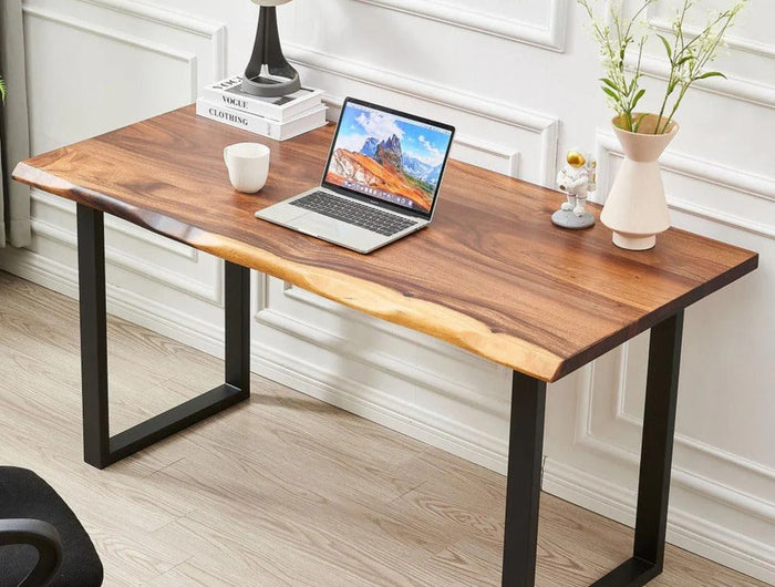 A wooden table with a natural edge top and black metal legs. The tabletop has a rectangular shape with slightly uneven sides, giving it a rustic appearance. The legs form a U-shape, providing sturdy support.