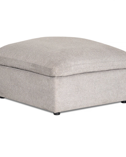 The My Cloud Slope 40 Ottoman offers cloud-like comfort with its cushioned top. Featuring a simple, boxy design, it rests on short black feet and boasts a textured light grey fabric finish, perfect for those seeking cozy furnishings.