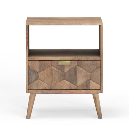 The Mango Geometric Nightstand is a handcrafted bohemian piece made of natural-finish mango wood, featuring angled legs, a drawer with a geometric pattern and small rectangular brass handle, plus an upper open shelf.