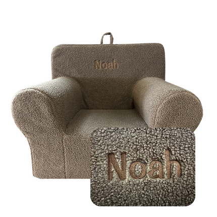 The My Cloud Kidz Chair is a small beige Sherpa armchair with Noah embroidered in brown on the backrest. It features a fuzzy texture and rounded armrests, showcasing customizable furniture with an embroidery close-up included.