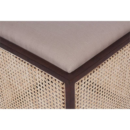 Close-up of an Upholstered Stool With Cane featuring a dark wood frame and beige woven wicker sides. Topped with a smooth, light gray cushion, this multifunctional accent piece exhibits texture and quality craftsmanship.