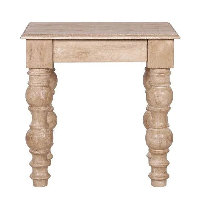 The French Country Side Table is crafted from solid mango wood, featuring a square top and intricately carved thick round legs. Its distressed natural finish adds to its rustic, antique charm, exuding a classic French-country design.