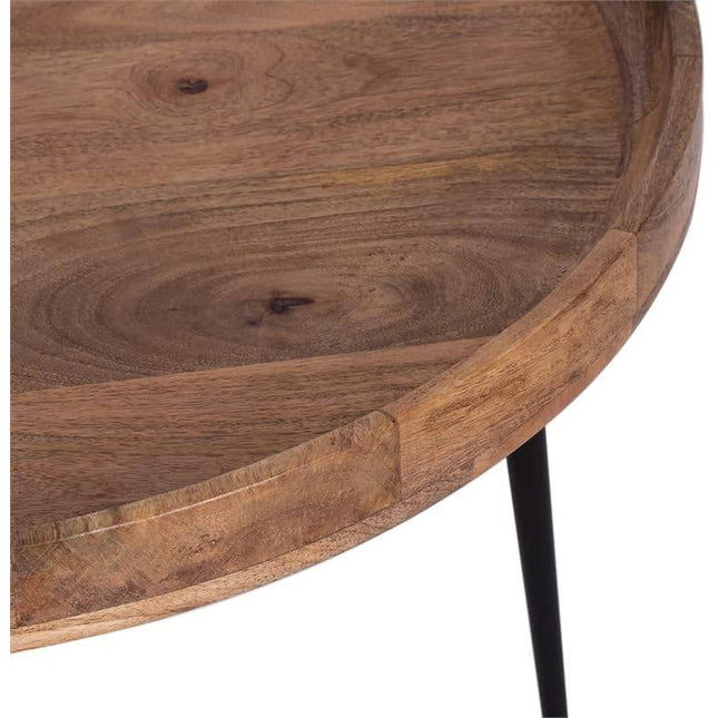 Introducing the Mango Bowl Coffee Table: a circular piece crafted from mango wood featuring a smooth surface and natural grain. This mid-century inspired table boasts a raised edge and is elegantly supported by slender black metal legs.