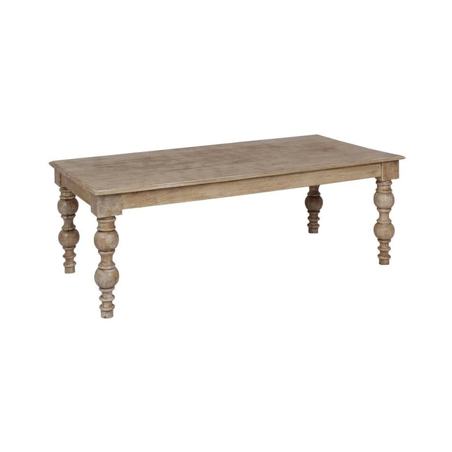 This French Country Coffee Table features a large rectangular top and four intricately carved legs with a rustic natural wood finish, highlighting the grain and texture of solid mango wood. Its perfect for adding charm to any farmhouse-style living room.