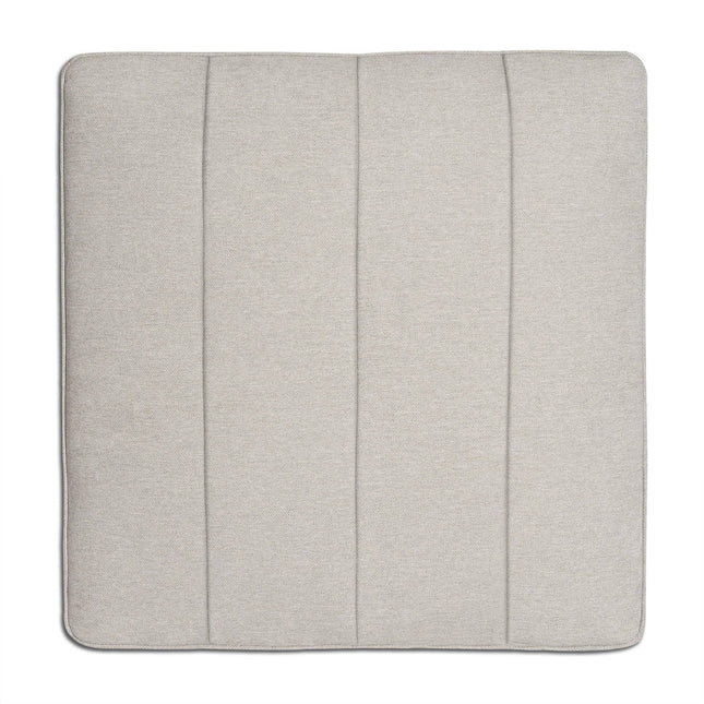 The Millenium Ottoman features a square, light gray seat cushion with visible seams that form three vertical panels, enhancing its modern luxury appeal. The smooth, soft fabric promises comfort and simplicity, making it perfect for any modular sofa setup.