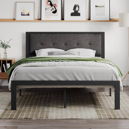 A modern bedroom features the Modena Platform Bedframe + Headboard with gray bedding and a green throw. Framed art adorns the wall, while a wooden nightstand with a plant sits on the left, paired with a floor lamp on the right. A striped rug covers the floor.