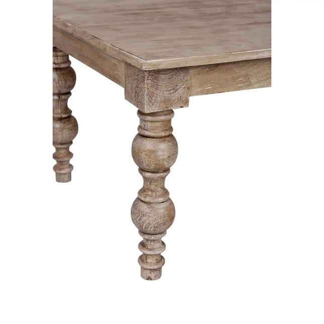 Close-up of the French Country Coffee Tables solid mango wood legs, intricately carved and turned. The rustic, weathered tabletop adds vintage charm perfect for a farmhouse-style living room, with the focus on the corner showing off its craftsmanship.
