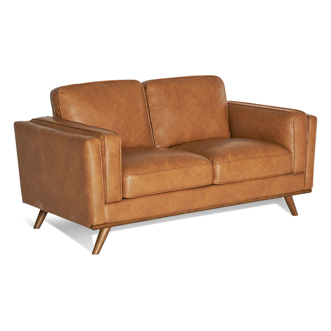The Maddox Loveseat is a mid-century modern piece in brown leather with durable construction, sleek lines, two cushions, and angled wooden legs, set against a plain white background.