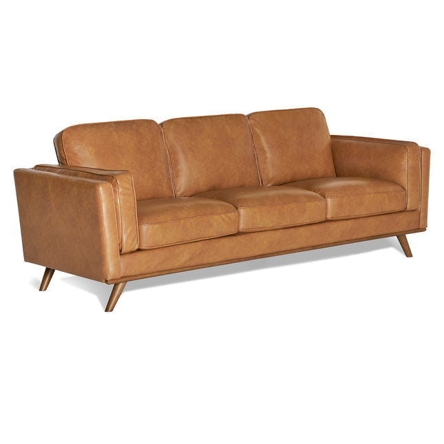 The Maddox Sofa showcases a mid-century modern style with plush leather cushions in a caramel hue. Its three-seat design and angular wooden legs offer a sleek, minimalist touch, ideal for any contemporary living area.