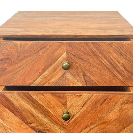 Close-up of the MCM Bedside Table, made from solid mango wood with two partially open drawers in a geometric chevron pattern. Each drawer has a round brass knob, and the warm brown wood displays natural variations.