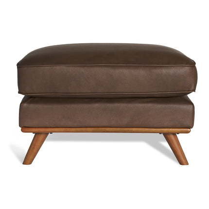 Meet the Maddox Ottoman—crafted in brown leather with a cushioned top and short, angled wooden legs. Its sleek rectangular form perfectly complements any living area, while its mid-century design adds subtle style.