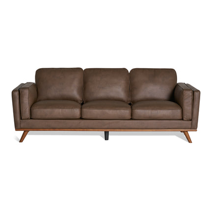 The Maddox Sofa is a mid-century modern piece featuring brown leather upholstery, plush cushions, and elegant wooden legs. With its sleek design highlighted by straight lines and a minimalist style, it offers a sophisticated look.
