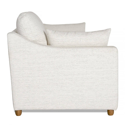 Side view of the My Cloud Slope Sofa, a white fabric piece with a pillow, wooden legs, and minimalist design. It features slightly curved armrests and subtle fabric texture. Machine-washable covers add convenience.