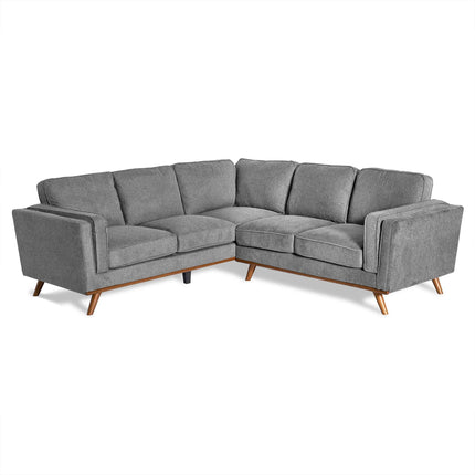 The Maddox is a gray, L-shaped sectional sofa featuring tufted cushions and angled wooden legs. Its mid-century modern design, plush seating, and armrests add both comfort and style to any living room.