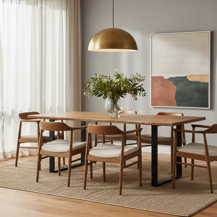 Live Edge acacia dining table staged in a warm modern dining room with wood chairs, brass pendant light and greenery