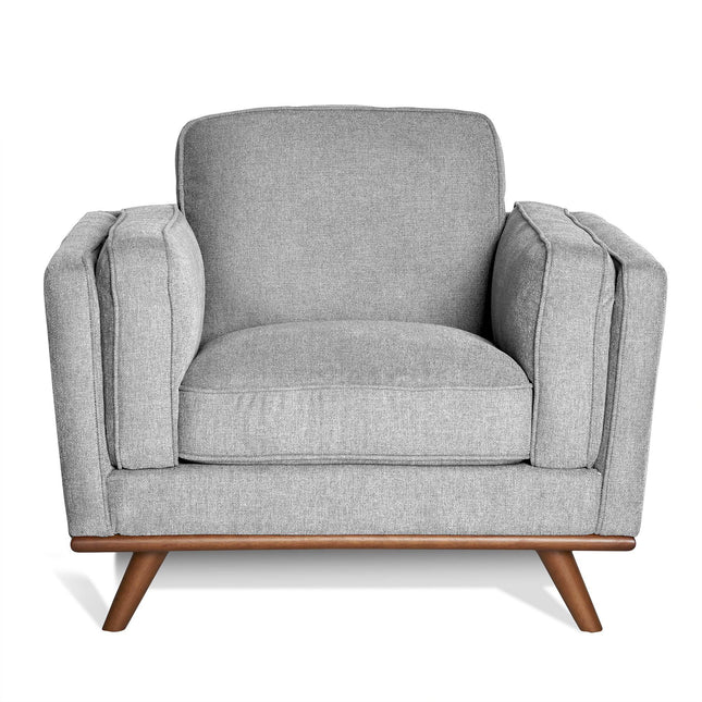 Discover the Maddox Chair, a mid-century modern masterpiece with a stylish boxy design. This gray armchair includes plush cushions, wooden legs, and thick armrests against a white backdrop for timeless appeal.