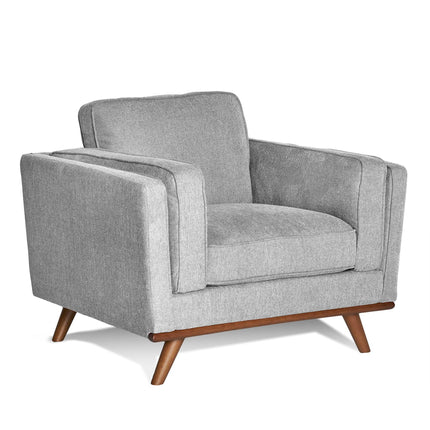 The Maddox Chair is a modern grey armchair with a boxy design, plush seat and back cushions, clean lines, and wooden tapered legs. It adds mid-century modern style that perfectly complements the Maddox Sofa Set.