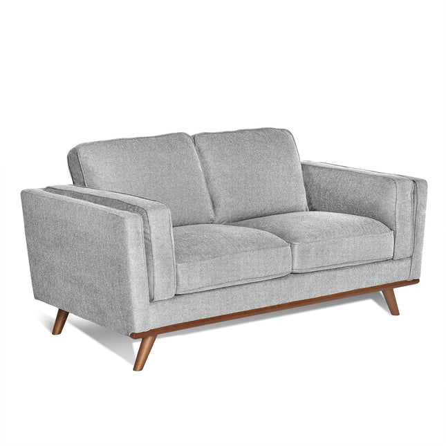 The Maddox Loveseat features a mid-century modern design with plush cushions, soft gray upholstery, wide armrests, durable construction, and is highlighted by tapered wooden legs.