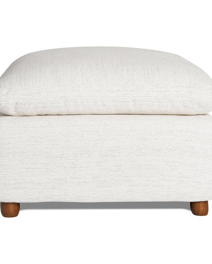 The My Cloud Slope 30 Ottoman features a cream color with a cushioned, textured top and wooden legs. Its simple, modern design offers customizable comfort, perfect for a living room or lounge area.