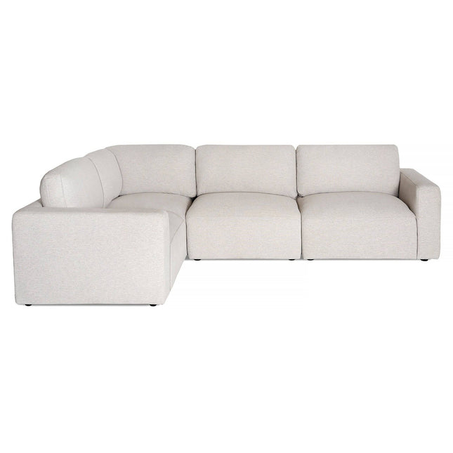 The Lugano Sectional is a light gray L-shaped sofa with plush cushions and wide armrests. Inspired by Italian luxury, it offers three main seating areas for comfort. Its minimalist design features small, invisible legs that give a floating appearance, enhancing any space.