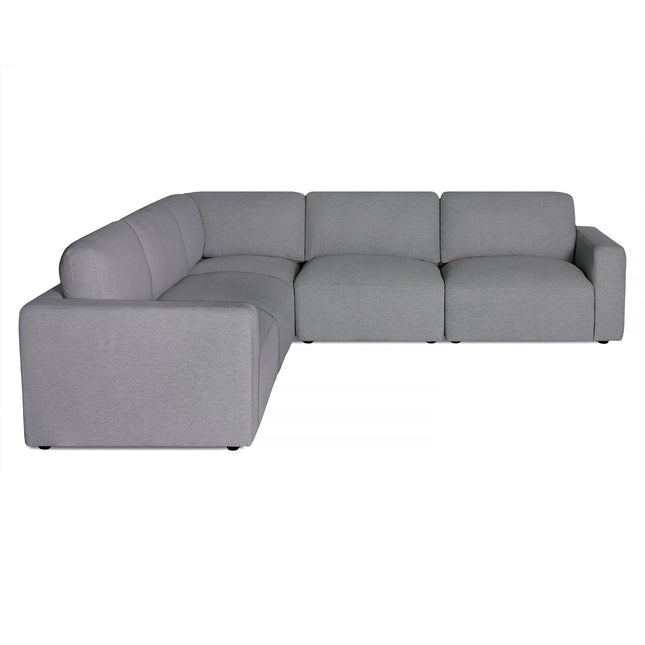 The Lugano is a gray L-shaped sofa combining Italian luxury with minimalist design. It features plush cushions, modern structure, clean lines, and smooth upholstery, ideal for contemporary living spaces.