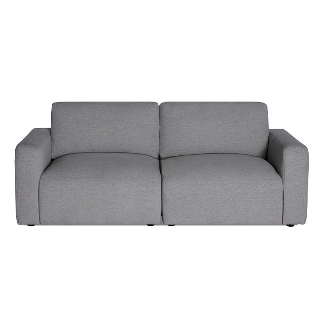 The Lugano Sectional is a modern, minimalist gray sofa with plush cushions and low arms. It features a simple, boxy design upholstered in soft fabric, perfect for adding contemporary Italian luxury to any chic living room or office space.