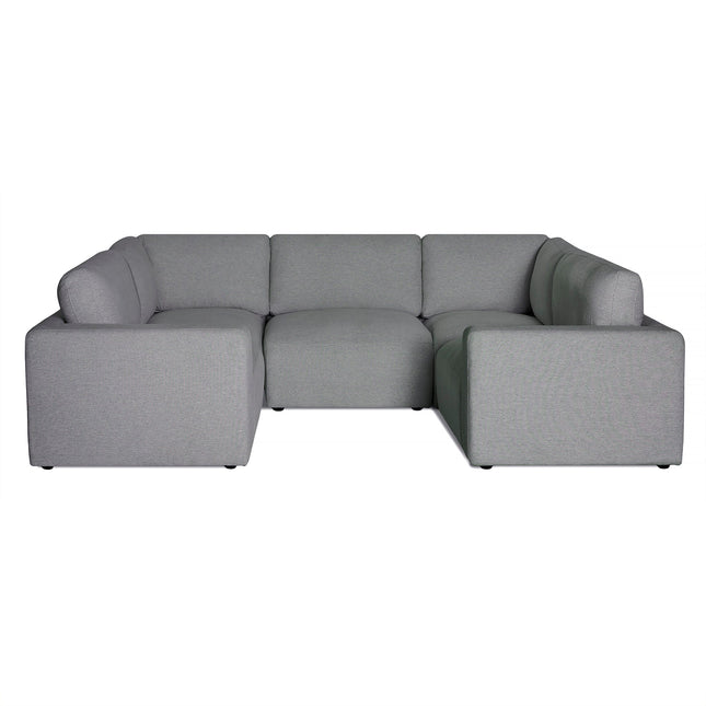 The Lugano is a gray L-shaped sectional with a minimalist Italian luxury design. It has thick square armrests, plush cushions for comfort, and a low backrest for modern appeal. The fabric is smooth and uniformly colored.