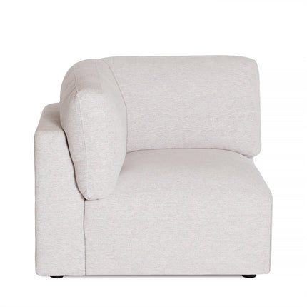 Side view of the light gray Lugano Corner sectional, crafted from premium materials. It has plush padding and minimalistic clean lines with a textured fabric finish, on small black feet. Offers diverse configuration possibilities.