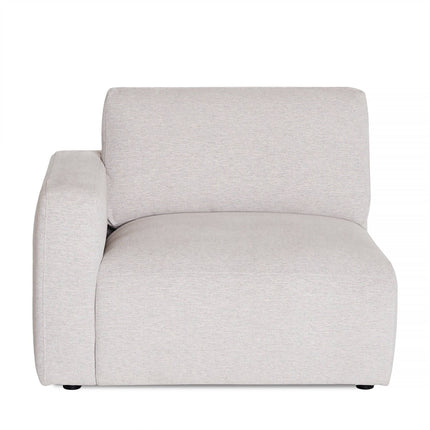 The Lugano Left Arm is a modern armchair with a minimalist design, featuring a light gray fabric and a single left armrest. It offers plush, premium material cushions and an invitingly soft backrest for comfort. Its flat base enhances its style and simplicity.