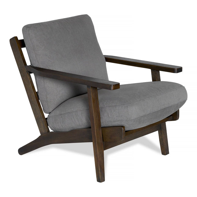 The Peyton Chair is a stylish wooden armchair with a dark brown frame and soft grey cushions on the seat and backrest. Featuring angled armrests and legs, it offers contemporary mid-century style and comfort to any space.