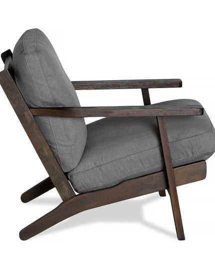 Side view of the Peyton Chair, featuring a stylish dark wooden frame and gray cushions. Its comfortable design includes an angled backrest and minimalist aesthetic, blending mid-century and contemporary styles seamlessly.