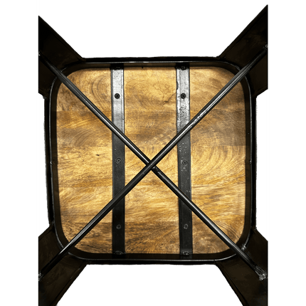The wooden kitchen table, made from rich Mango wood with a square top, has two vertical metal bars and diagonal crossbars underneath for support. It pairs perfectly with the modern Mango Counter Stool.