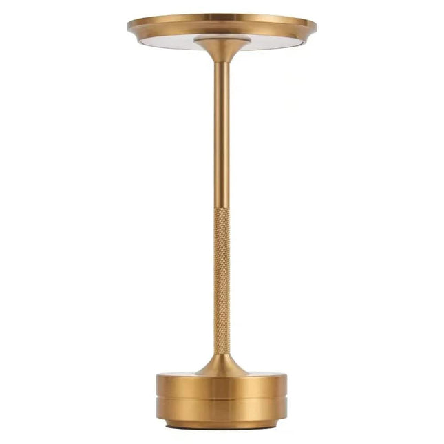 The Lumin Lamp is a sleek, modern, gold-colored table lamp featuring a round base, slim neck, and flat circular shade. This LED rechargeable lamp combines versatile lighting with an elegant design, offering a minimalist look and metallic finish.