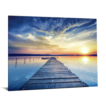 The Sunset Dock is a museum-quality artwork featuring a wooden pier over a calm lake with sunset reflections and dramatic clouds transitioning from deep blue to warm orange, creating a serene scene that resembles tempered glass, ideal for home or office decor.