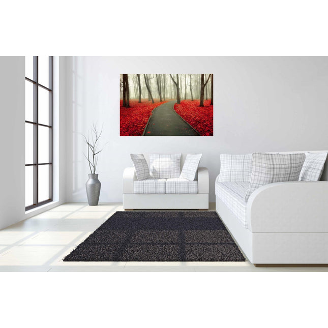 A modern living room boasts white sofas, a dark rug, and Red Autumn, a large picture depicting a misty forest path with vibrant red leaves, akin to museum-quality artwork. The space includes a tall plant in a gray vase and expansive windows that fill the room with natural light.