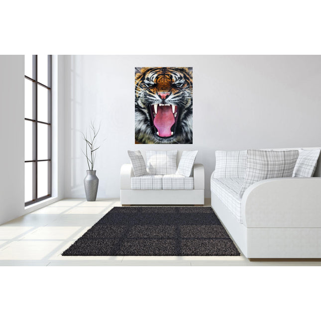 A modern living room showcases a white sofa with plaid pillows and a black rug. The Roaring Tiger, a museum-quality artwork, is displayed above the sofa. Natural light pours in through tall windows on the left, and a tall potted plant stands beside the sofa.
