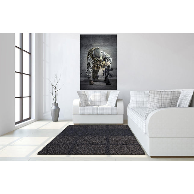 A minimalist living room features a white sofa with plaid cushions. The wall displays the Kneeling Soldier, a museum-quality photo. Beside the sofa, a tall vase with thin branches rests on a tempered glass stand. A dark gray rug complements the light wood floor.