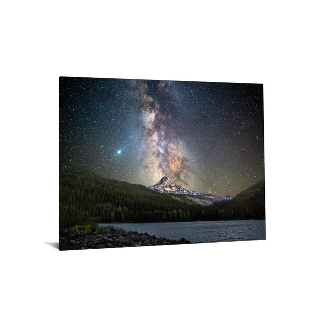 The Starry Mountain artwork showcases a vibrant Milky Way galaxy stretching across the night sky above a mountain peak, surrounded by a forest. A calm lake reflects this museum-quality scene, with rocky shores in the foreground, as stars illuminate the landscape with a serene glow.