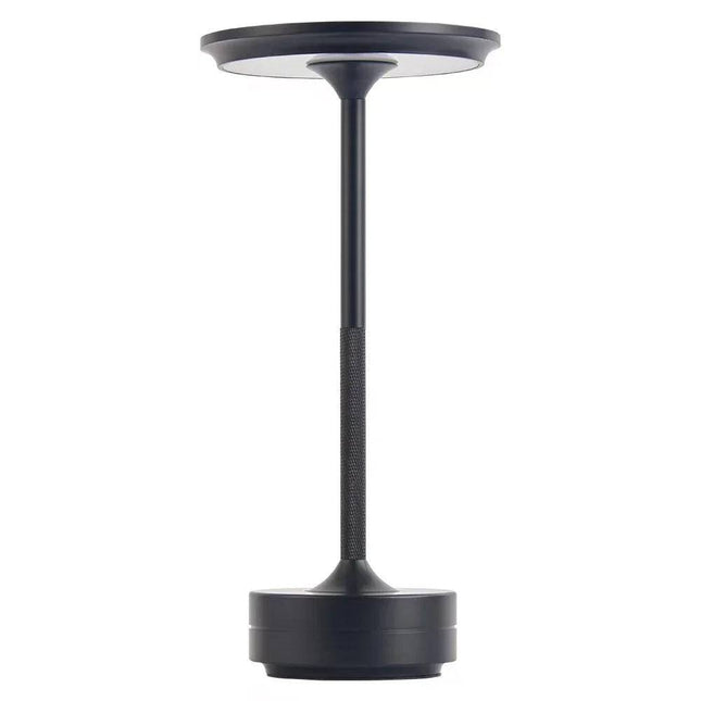 The Lumin Lamp is a sleek, modern LED rechargeable table lamp in black, featuring a circular base, slender stem, and round flat top. Its minimalistic design offers versatile lighting that perfectly complements contemporary decor.