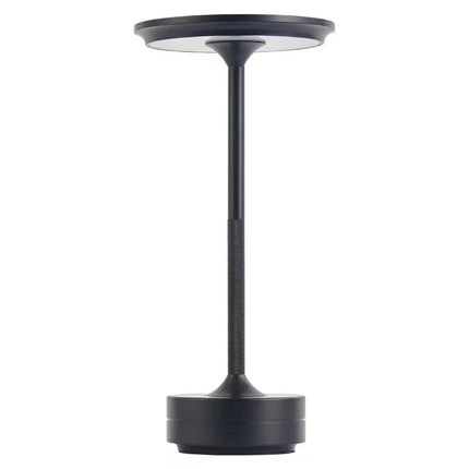 The Lumin Lamp is a sleek, modern LED rechargeable table lamp in black, featuring a circular base, slender stem, and round flat top. Its minimalistic design offers versatile lighting that perfectly complements contemporary decor.