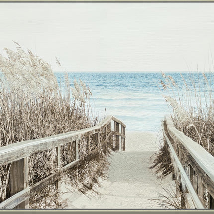 The Beachwalk takes you through towering grass to a sandy shoreline, where gentle waves paint a stunning scene beneath a pale sky. Along the path, sparse sea oats dance in the breeze.
