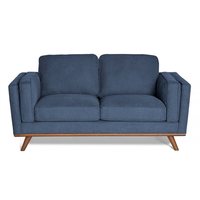 The Maddox Loveseat is a blue, mid-century modern piece with square cushions, wide armrests, a sturdy wooden base, and angled legs for durability and contemporary style.