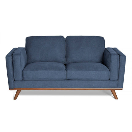 The Maddox Loveseat is a blue, mid-century modern piece with square cushions, wide armrests, a sturdy wooden base, and angled legs for durability and contemporary style.