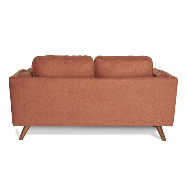 The image shows the Maddox Loveseat, a mid-century modern piece with brown upholstery and two cushions. It has a simple rectangular design and stands on four angled wooden legs, showcasing its durable construction.