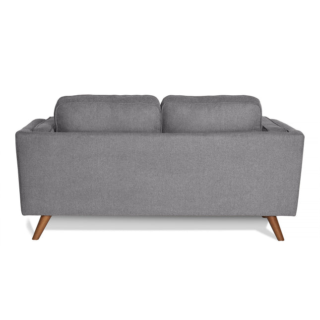 The Maddox Loveseat, a modern gray piece with clean lines, showcases two back cushions and wooden legs from the back. It embodies a sleek mid-century modern design with durable construction.