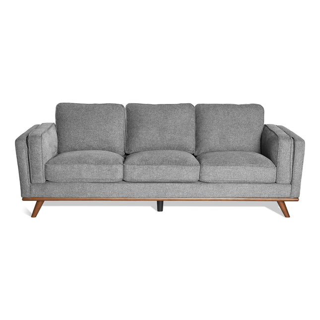 The Maddox Sofa exudes mid-century modern style with its sleek wooden legs and plush gray cushions. Its minimalist design against a white background provides both elegance and comfort.