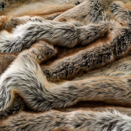 A close-up of the RCL Fur Throw reveals its rich brown, cream, and gray textures. Its faux fur appears soft and plush with wavy patterns that exude warmth and luxury, making it the perfect addition to any cozy space.