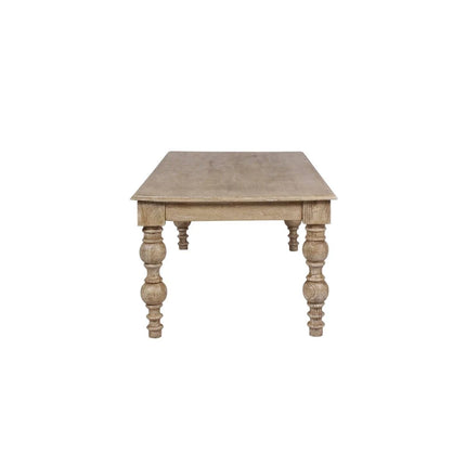 The French Country Coffee Table, crafted from solid mango wood with a rustic finish, features four intricately carved legs. Its simple, classic design beautifully showcases the distressed natural grain of the wood.