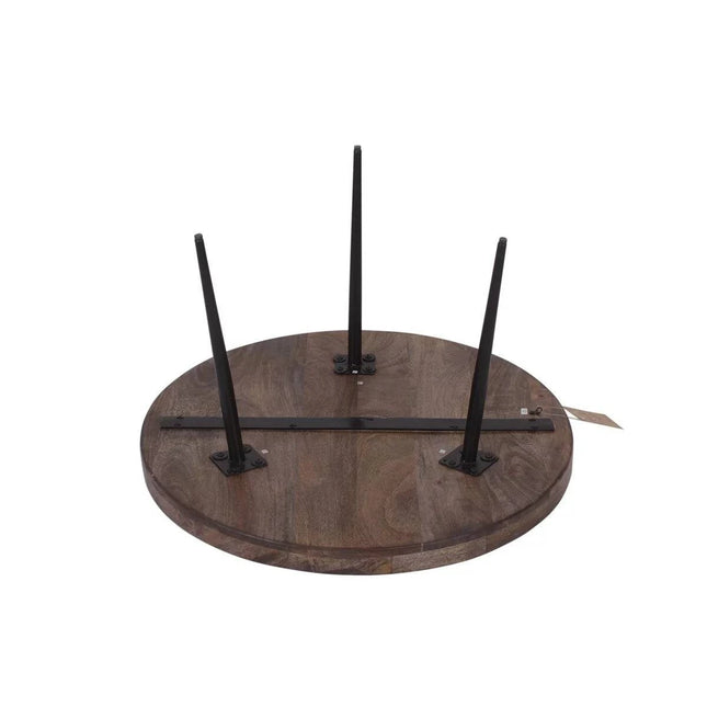 The Mango Bowl Coffee Table, crafted from ethically sourced round mango wood, lies upside down with three black metal legs attached, awaiting assembly.