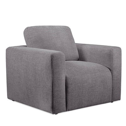 The Lugano Chair is a gray fabric armchair with a boxy design, wide armrests, and a cushioned backrest. Made from premium materials, it boasts a modern minimalist style that suits contemporary living spaces or the elegance of an Italian luxury setting.